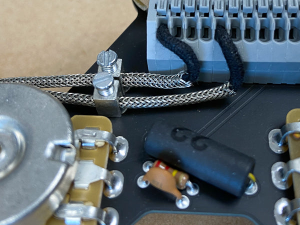 Vintage braided pickup wire being installed correctly in an ObsidianWire harness for Les Paul